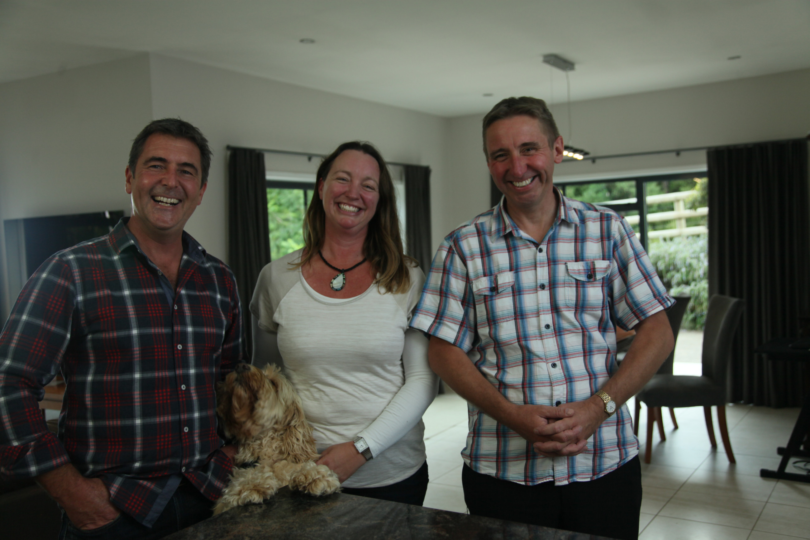 Three people smiling in their home