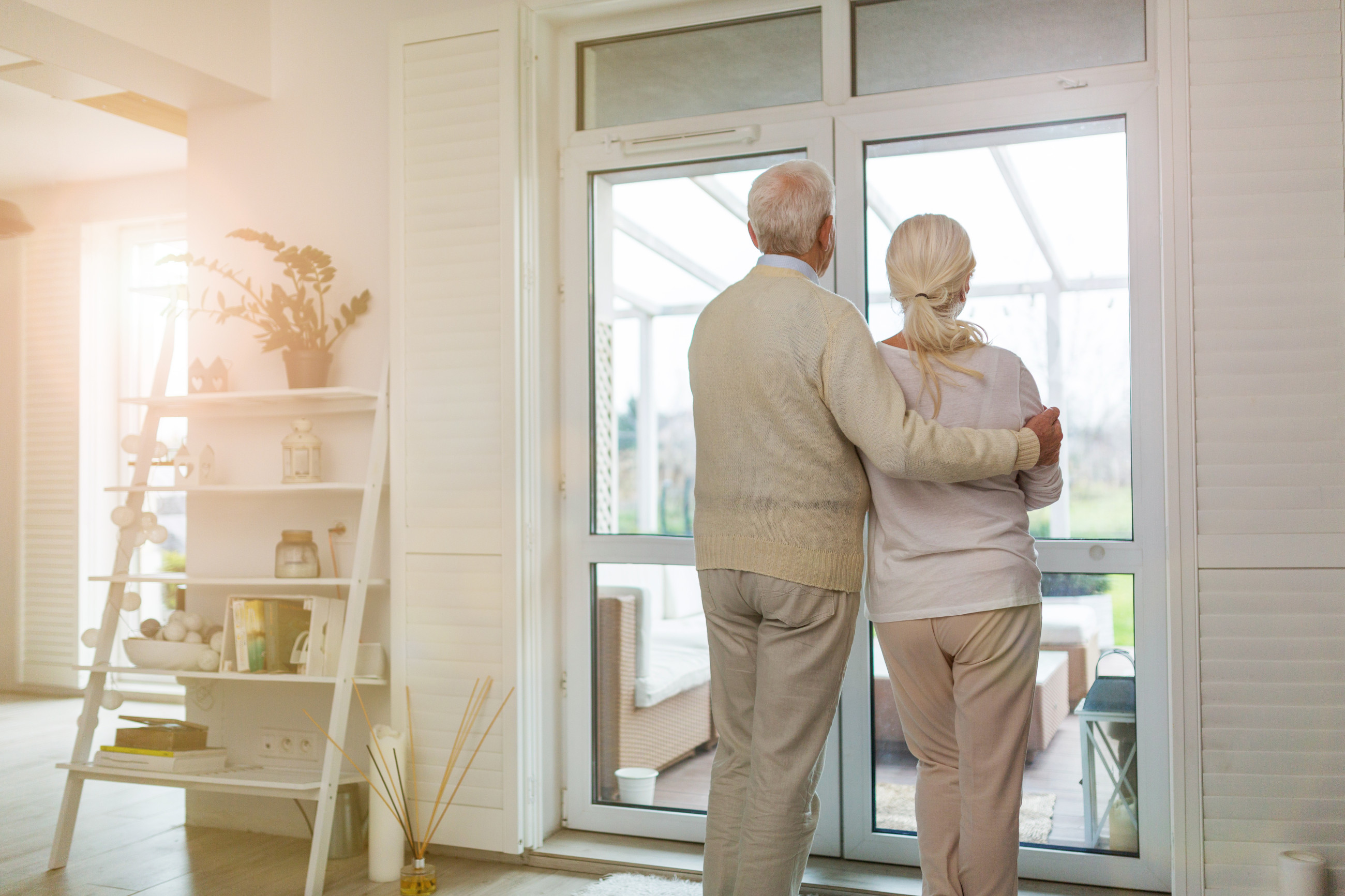 elderly couple looking out of double glazed windows